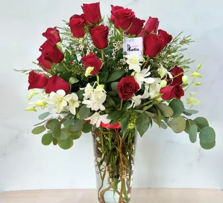 Arreglo floral de rosas rojas y orquídeas blancas en florero de cristal